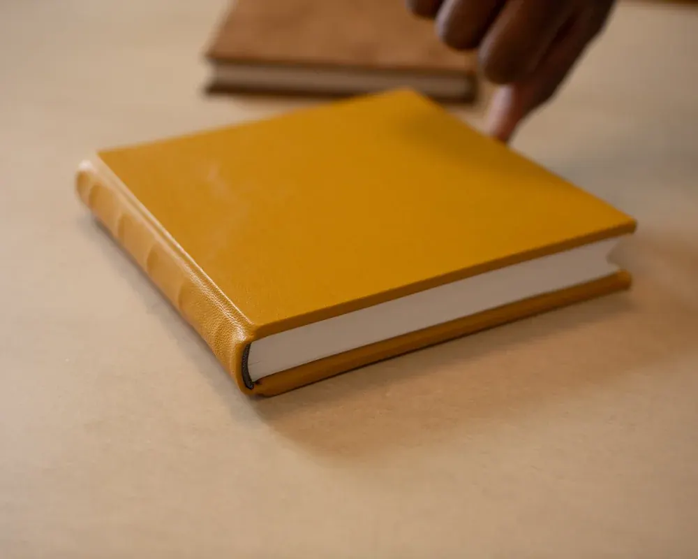 A closed leather-bound journal with a tan cover