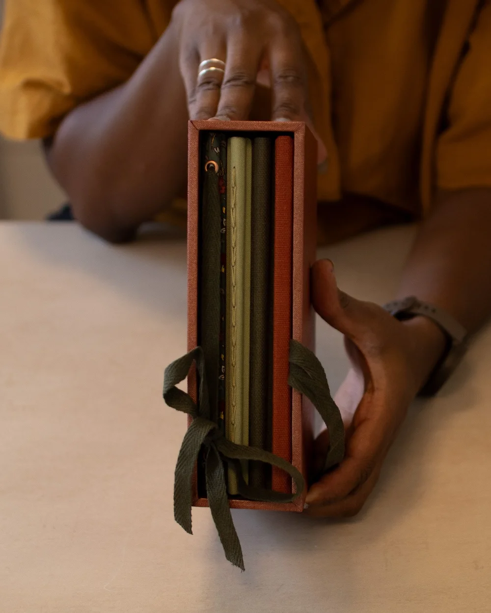 Person holding a box of several fabric swatches or sample strips.