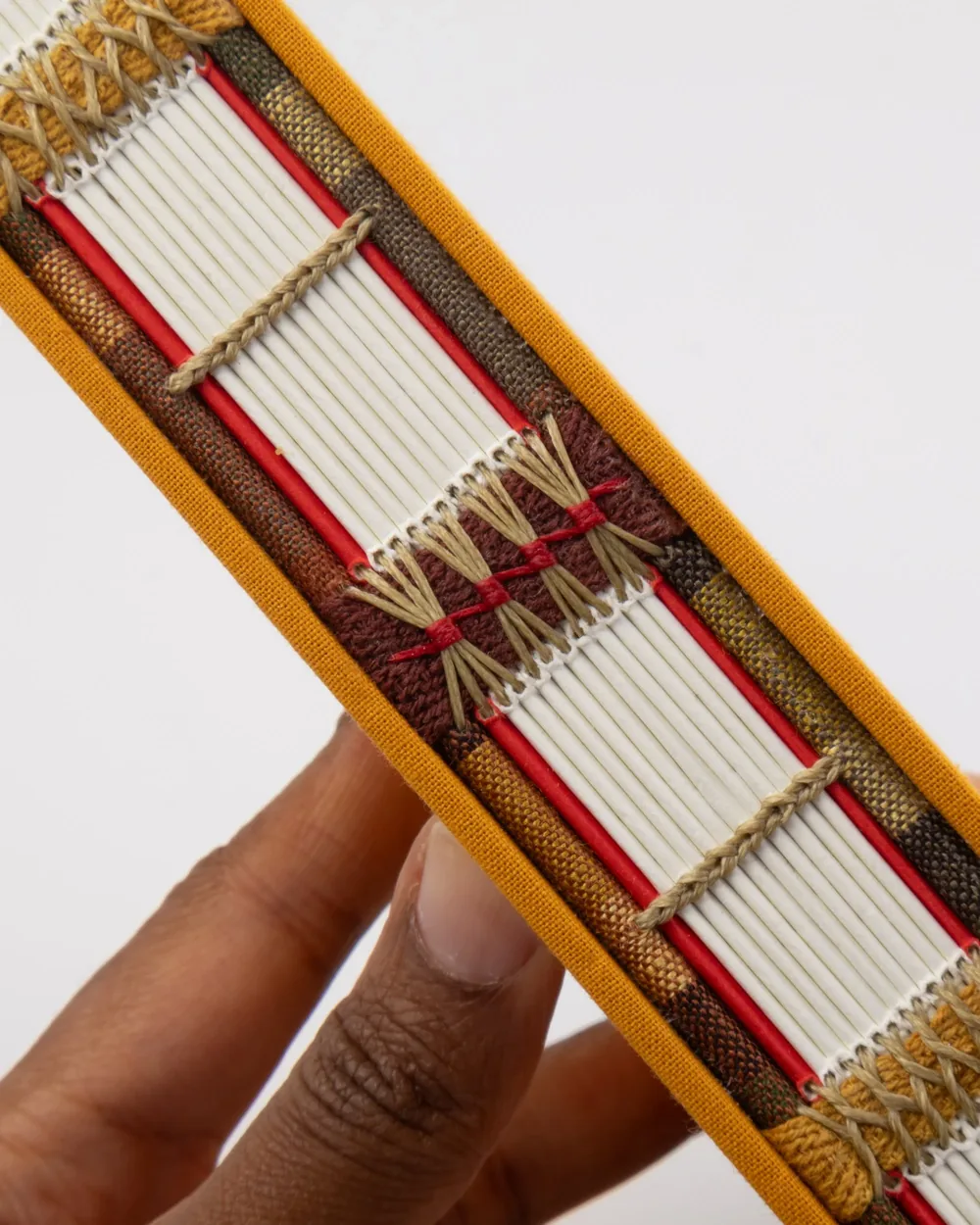 Close-up of a traditional woven backgammon set with white game pieces, red and brown decorative elements, and a yellow border.