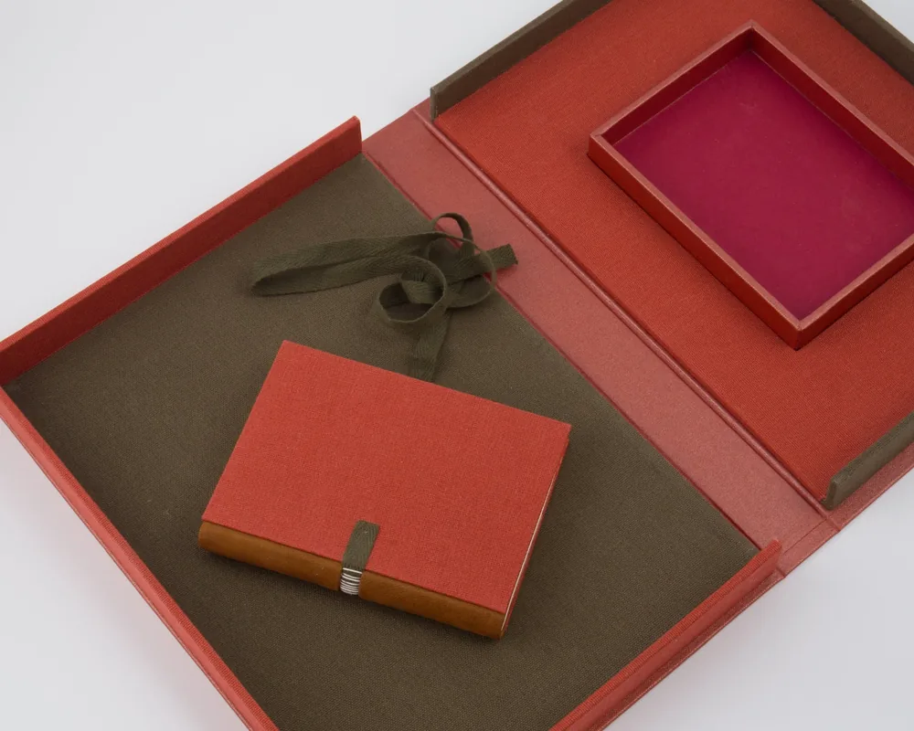 Red gift box with a matching notebook and an empty red square frame inside it.