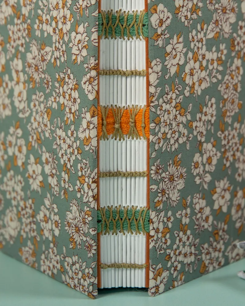 Close-up of a decorative floral fabric-covered book with embroidered details visible on the spine.