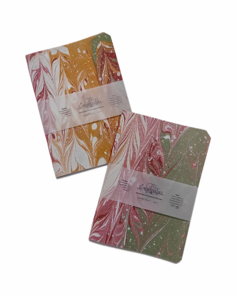 Marbled notebooks in yellow, red, white, and green colors with a translucent band labeled "Emperreitas."