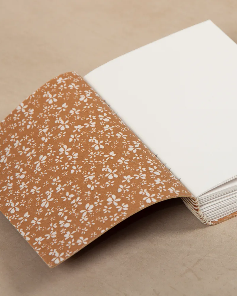 Open journal with a floral patterned cover and blank white pages